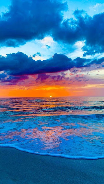 شاطىء البحر مع أمواج وشعاع الشمس البرتقالي